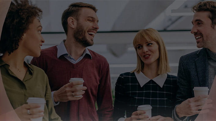 Four people laughing having coffee