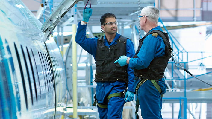 Two engineers inspecting plane fuselage.