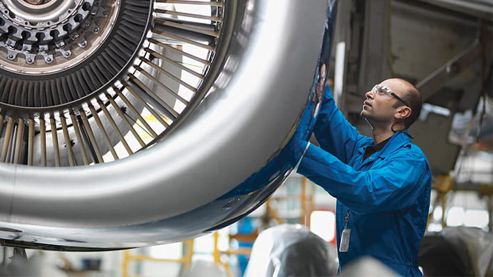 Man inspecting plane engine